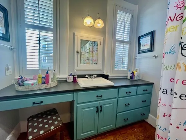 a bathroom with a sink mirror and window