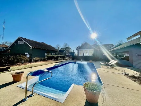 a view of a house with pool and chairs