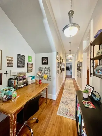 a room with stainless steel appliances kitchen island granite countertop furniture and a wooden floor