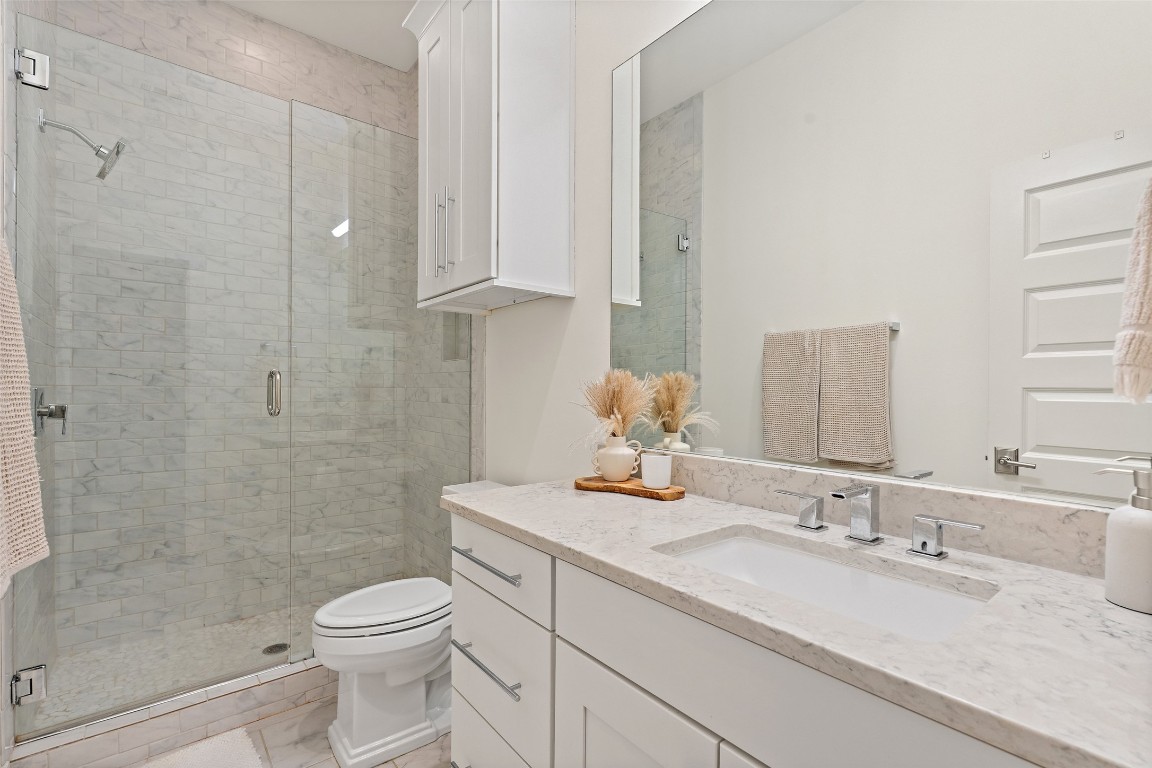 1002 Meriden Lane Austin, TX 78703 - Photo 25 of 35 a bathroom with a granite countertop sink toilet and shower