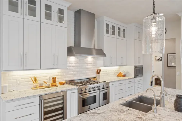a kitchen with stainless steel appliances granite countertop a sink stove and cabinets