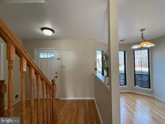 a view of a hallway with wooden floor and staircase