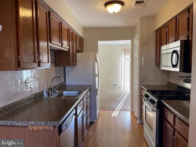 a kitchen with granite countertop a sink a stove and cabinets