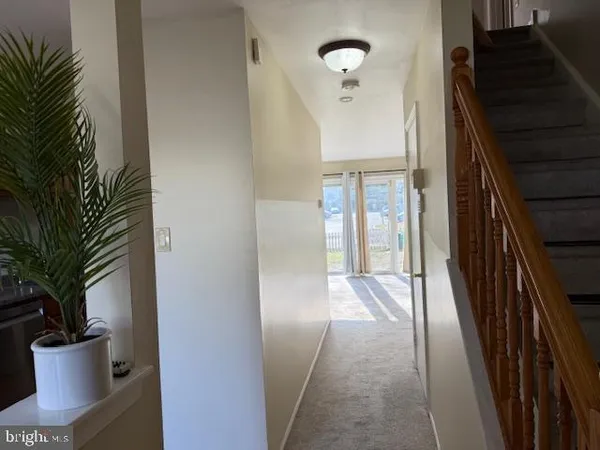 a view of a hallway to a livingroom with furniture and entryway