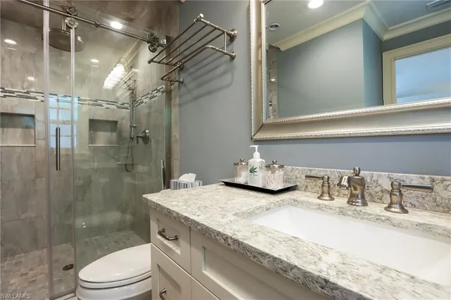 a bathroom with a granite countertop sink a toilet and shower