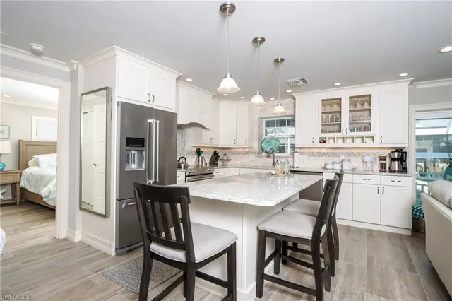 a kitchen with a dining table chairs refrigerator and stove