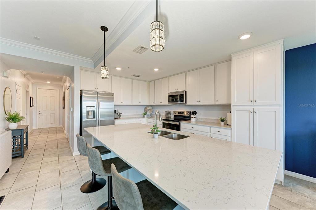 17902 Gawthrop Drive, Unit 307 Lakewood Ranch, FL 34211 - Photo 16 of 74 a kitchen with stainless steel appliances a table chairs refrigerator and microwave