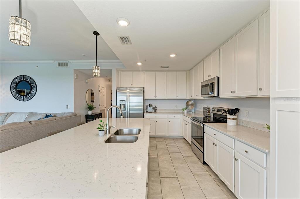 17902 Gawthrop Drive, Unit 307 Lakewood Ranch, FL 34211 - Photo 17 of 74 a kitchen with stainless steel appliances kitchen island granite countertop a sink and cabinets