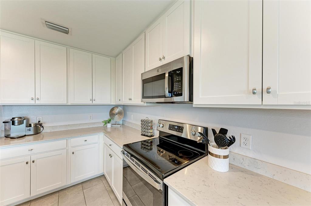 17902 Gawthrop Drive, Unit 307 Lakewood Ranch, FL 34211 - Photo 19 of 74 a kitchen with stainless steel appliances a white stove top oven and white cabinets