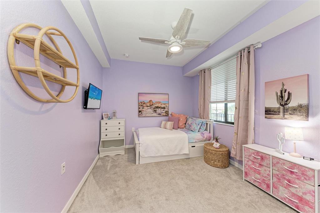 17902 Gawthrop Drive, Unit 307 Lakewood Ranch, FL 34211 - Photo 29 of 74 a spacious bedroom with a bed next to a window and a chandelier