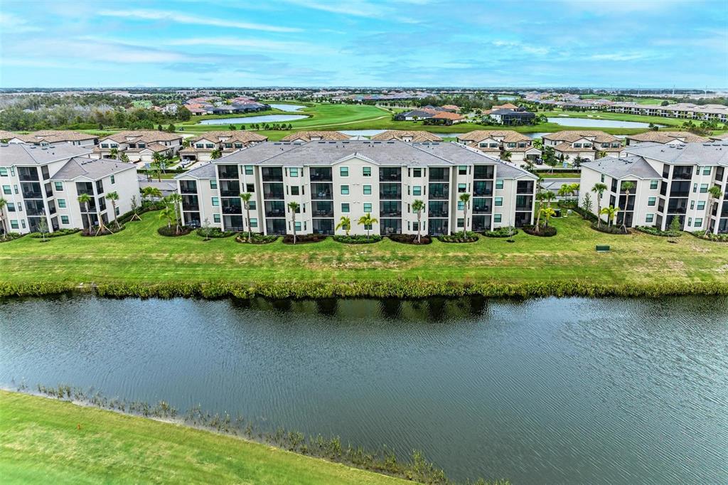 17902 Gawthrop Drive, Unit 307 Lakewood Ranch, FL 34211 - Photo 40 of 74 a view of a lake with a big yard and large trees