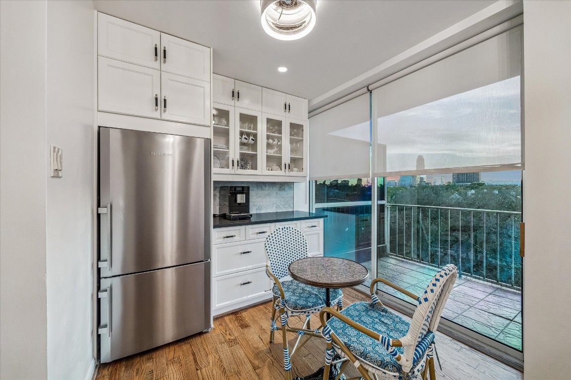 2200 Willowick Road, Unit 4D Houston, TX 77027 - Photo 11 of 36 a kitchen with stainless steel appliances a refrigerator a stove a sink and a dining table with garden view