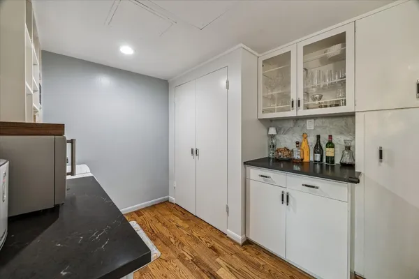 a bathroom with a granite countertop sink vanity mirror and toilet