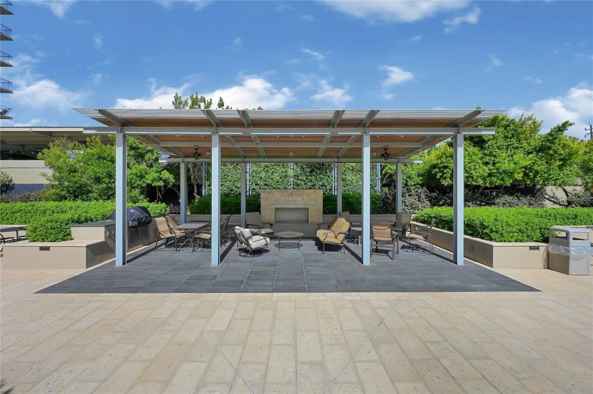2200 Willowick Road, Unit 4D Houston, TX 77027 - Photo 4 of 36 a view of a patio with table and chairs potted plants with wooden fence