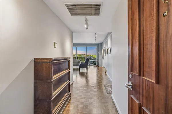 a kitchen with stainless steel appliances a stove a sink dishwasher a refrigerator and a dining table with wooden floor