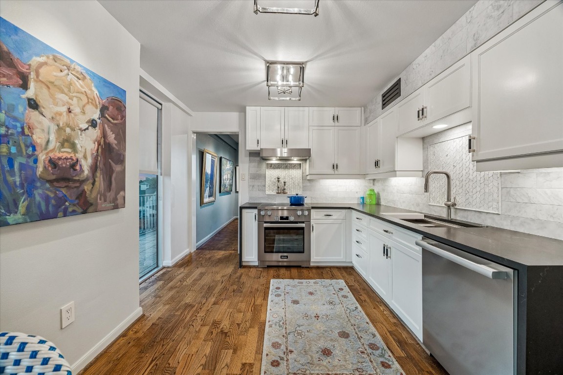 2200 Willowick Road, Unit 4D Houston, TX 77027 - Photo 10 of 36 a kitchen with stainless steel appliances a stove a sink dishwasher a refrigerator and a dining table with wooden floor