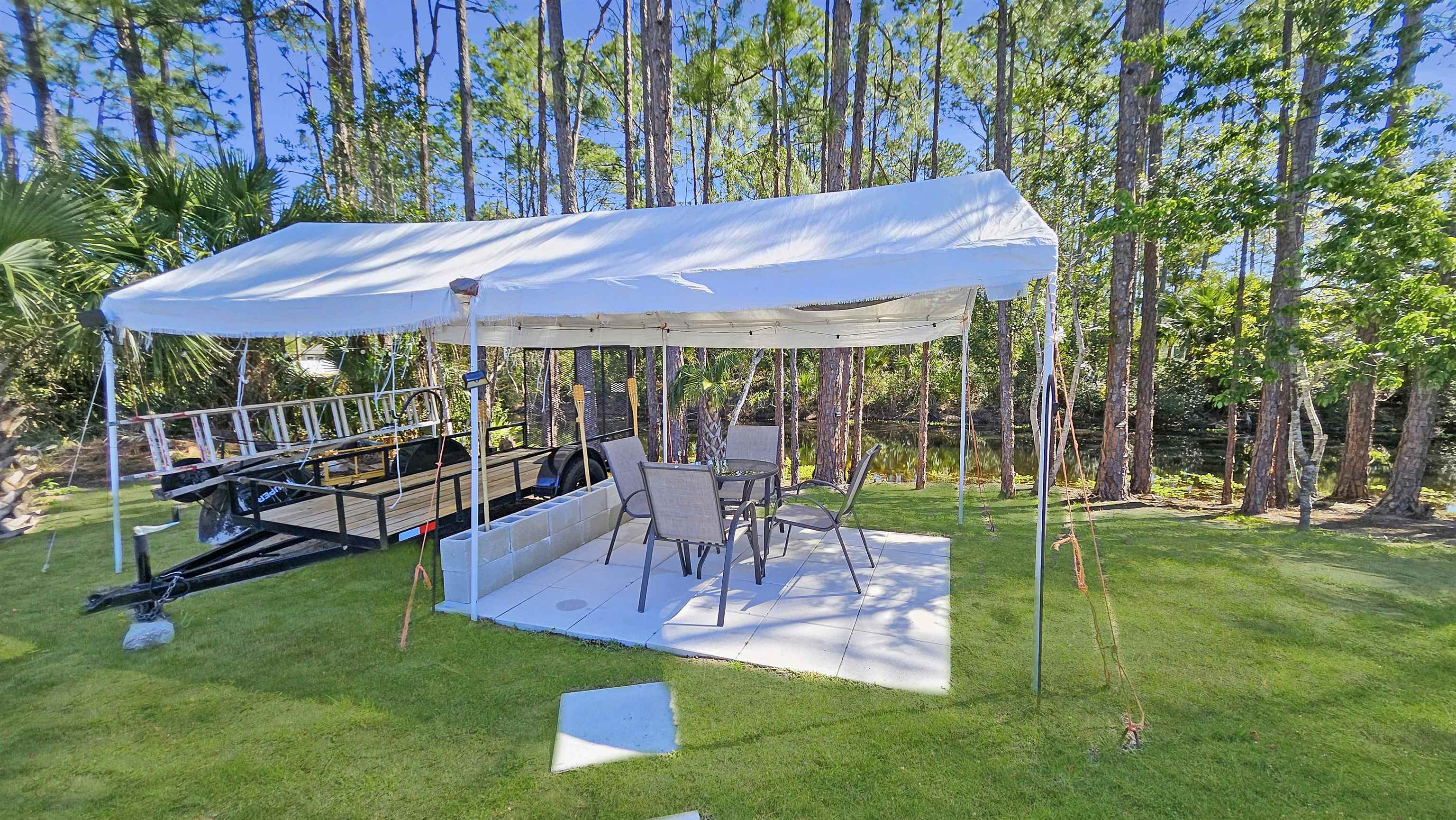 7 Smith Trail Palm Coast, FL 32164 - Photo 44 of 48 a view of a patio with table and chairs under an umbrella