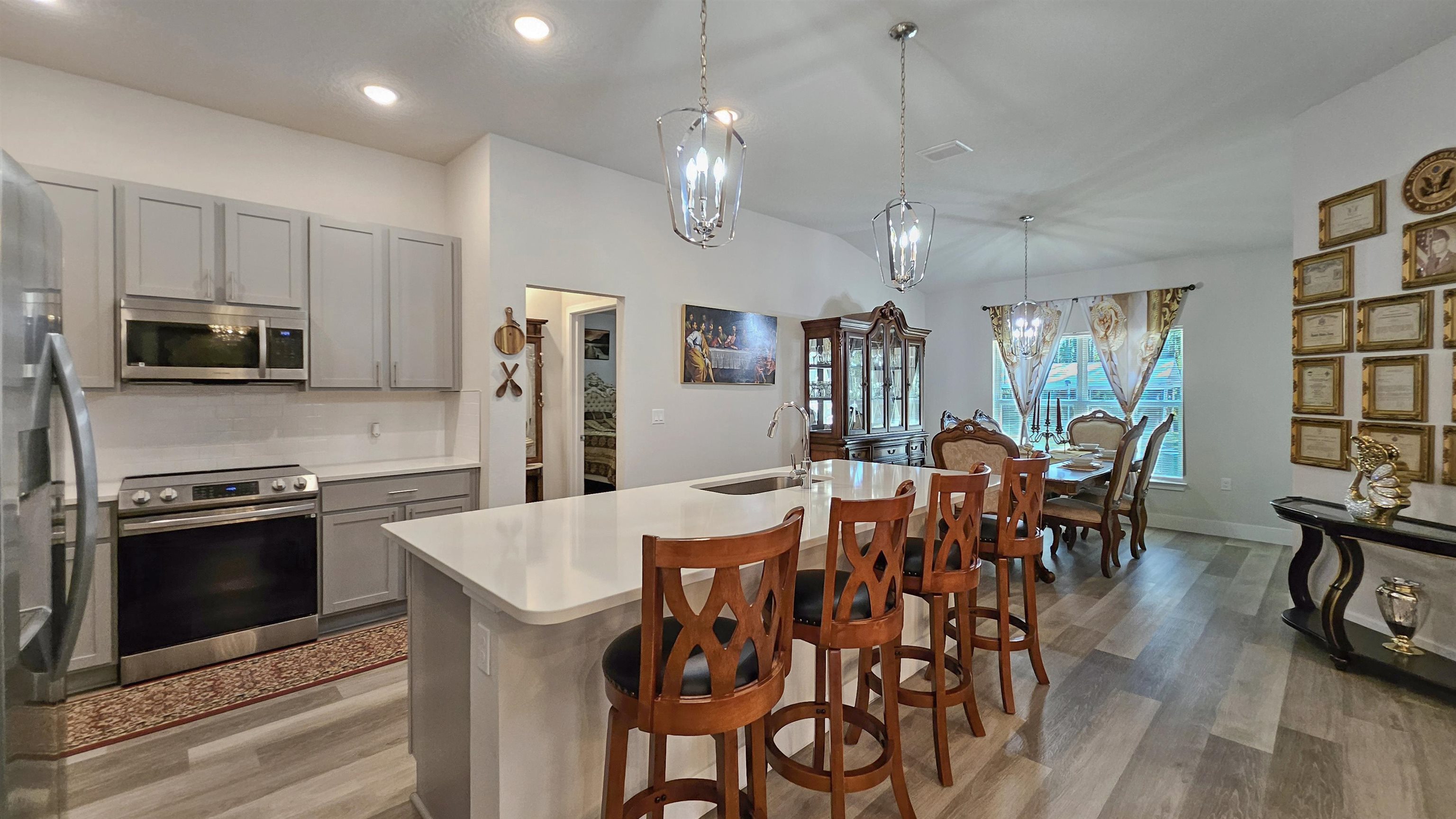 7 Smith Trail Palm Coast, FL 32164 - Photo 10 of 48 a large kitchen with granite countertop a table chairs stainless steel appliances and wooden floor