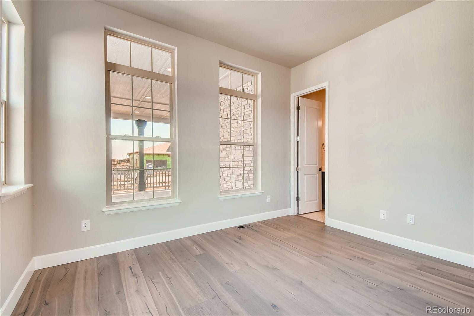 2293 Picadilly Circle Longmont, CO 80503 - Photo 17 of 35 an empty room with wooden floor and windows