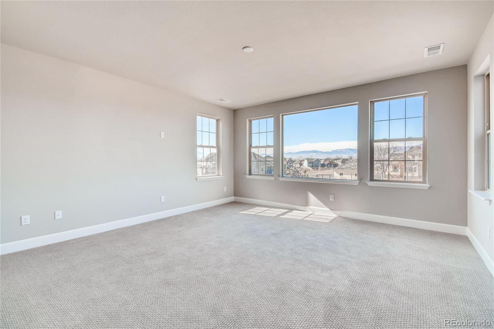 2293 Picadilly Circle Longmont, CO 80503 - Photo 23 of 35 an empty room with windows and view of kitchen