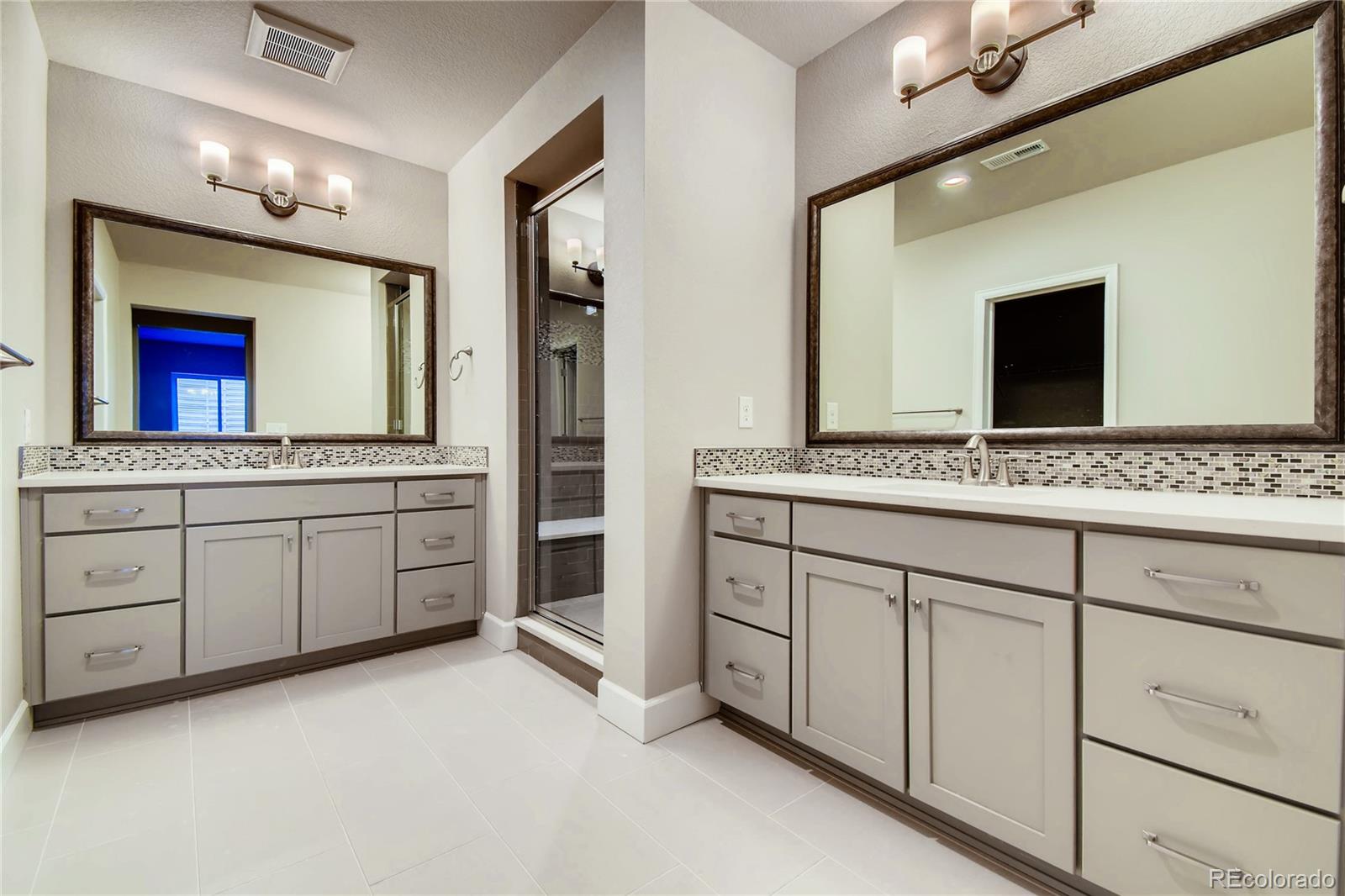 2293 Picadilly Circle Longmont, CO 80503 - Photo 32 of 35 a spacious bathroom with a granite countertop sink and a mirror
