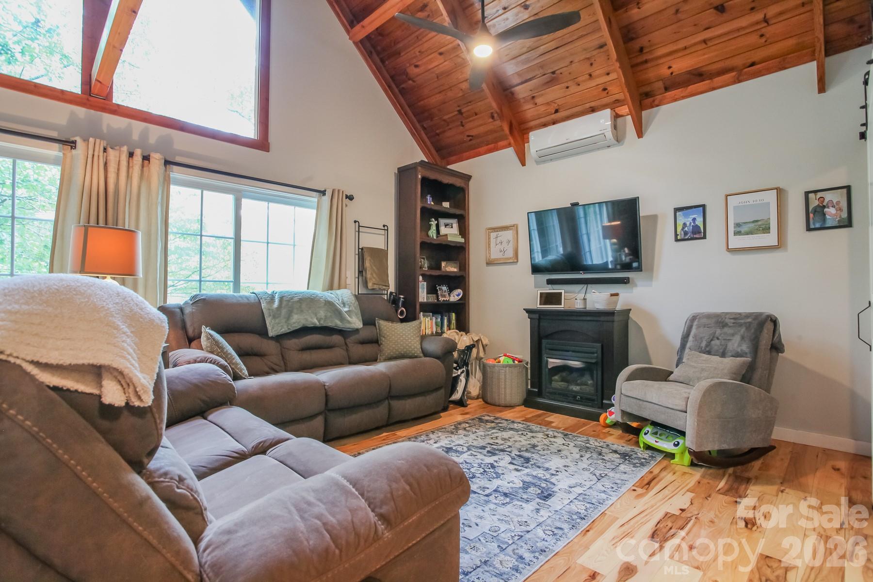 292 Wolf Creek Heights Road Almond, NC 28702 - Photo 18 of 47 a living room with furniture a flat screen tv and a fireplace