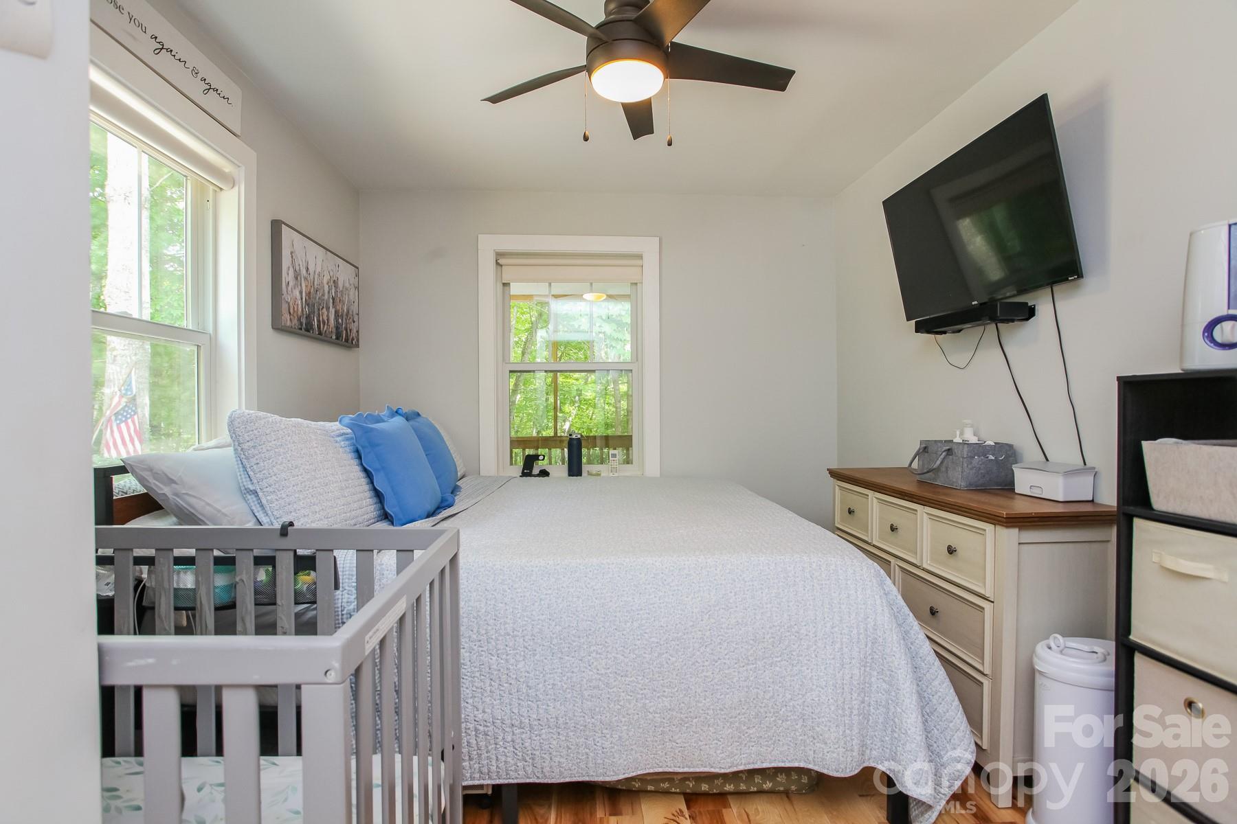 292 Wolf Creek Heights Road Almond, NC 28702 - Photo 24 of 47 a bedroom with a bed a flat screen tv and windows