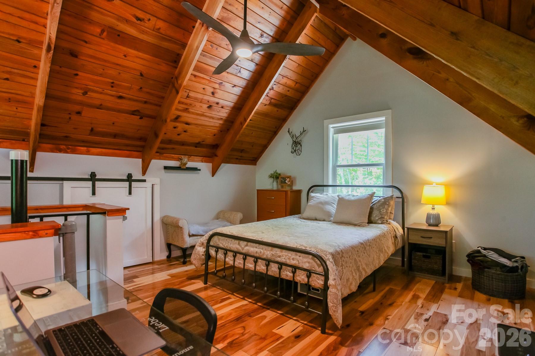 292 Wolf Creek Heights Road Almond, NC 28702 - Photo 30 of 47 a bedroom with a bed and wooden floor