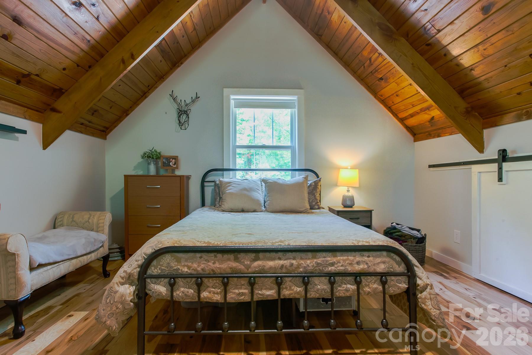 292 Wolf Creek Heights Road Almond, NC 28702 - Photo 32 of 47 a bedroom with a bed and wooden floor