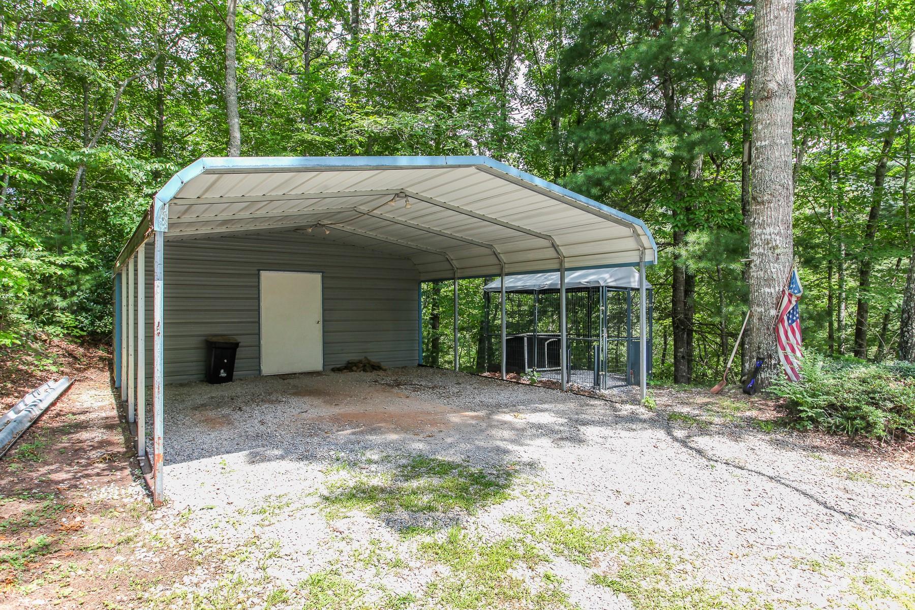 292 Wolf Creek Heights Road Almond, NC 28702 - Photo 36 of 47 a backyard of a house with large trees and a small barn
