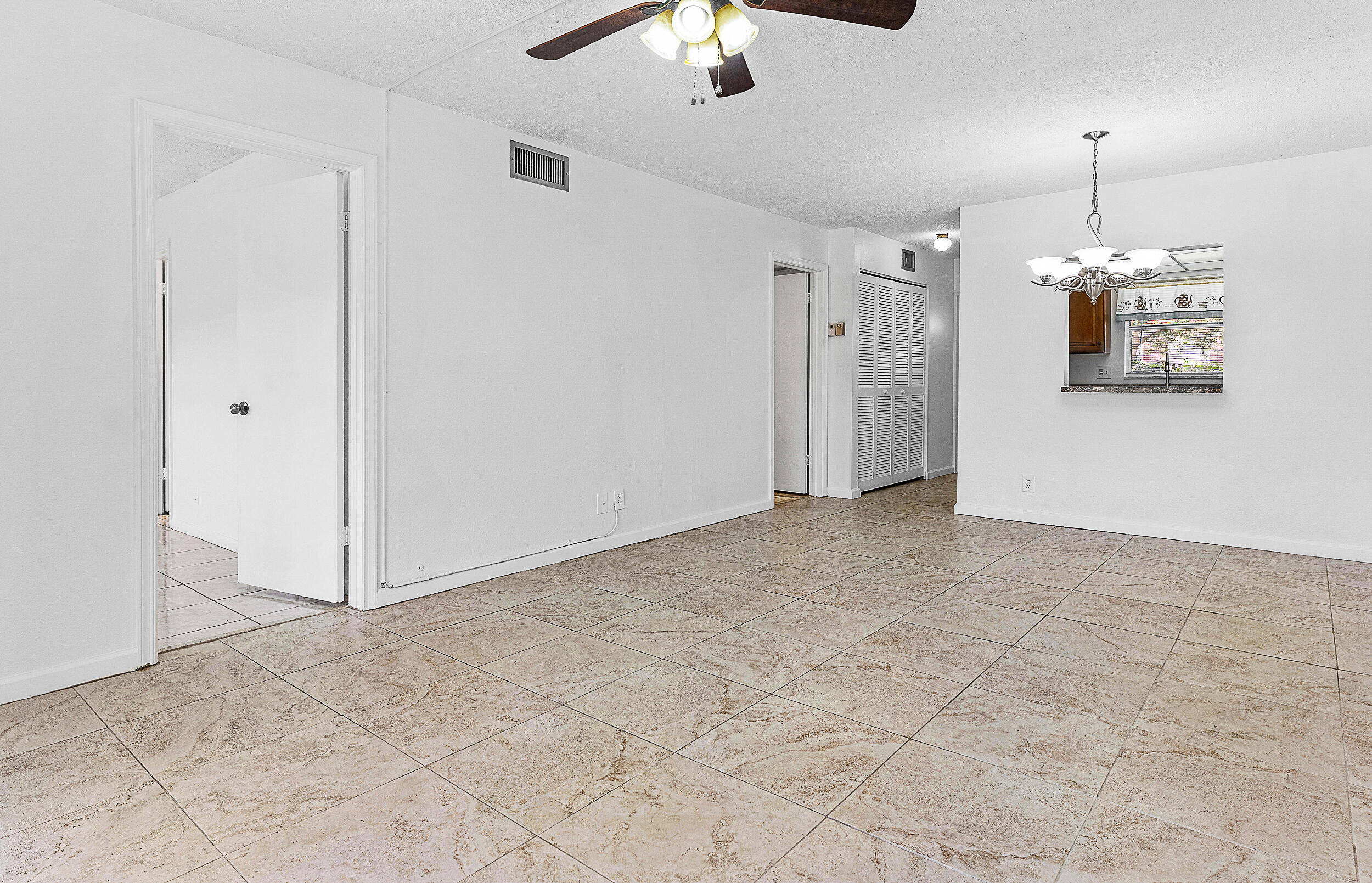 9855 Sandalfoot Boulevard, Unit 305 Boca Raton, FL 33428 - Photo 5 of 17 a view of a hallway with a chandelier fan