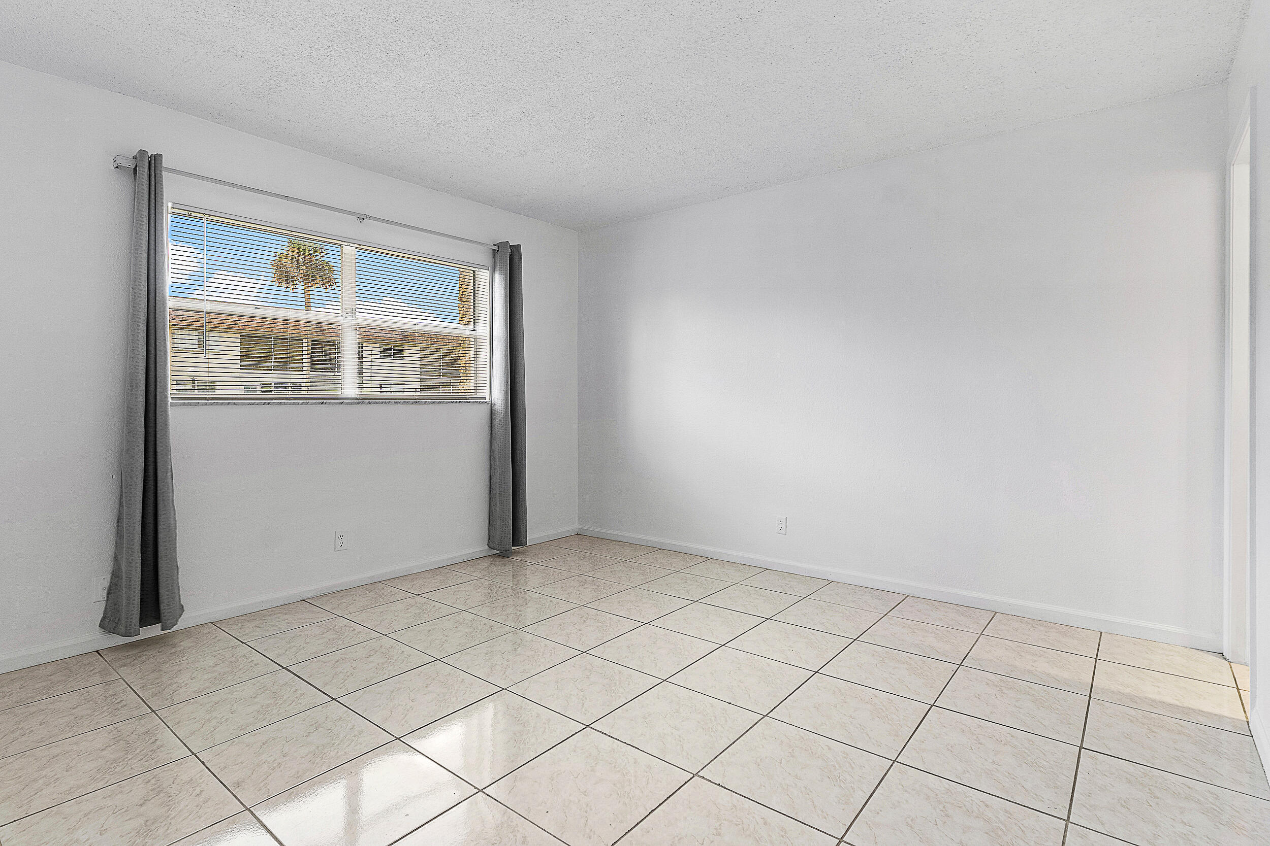9855 Sandalfoot Boulevard, Unit 305 Boca Raton, FL 33428 - Photo 6 of 17 an empty room with windows