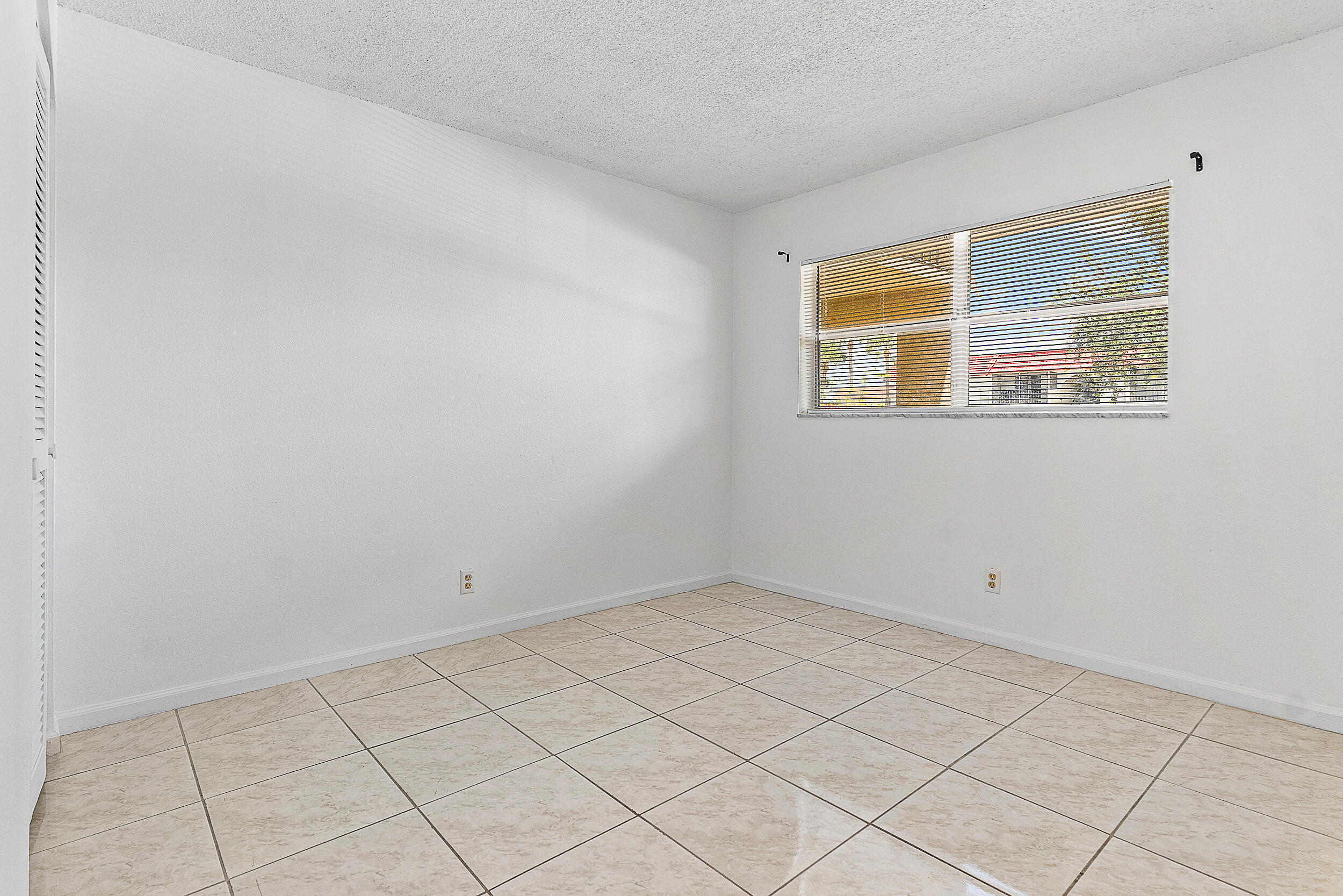 9855 Sandalfoot Boulevard, Unit 305 Boca Raton, FL 33428 - Photo 9 of 17 a view of an empty room with a window