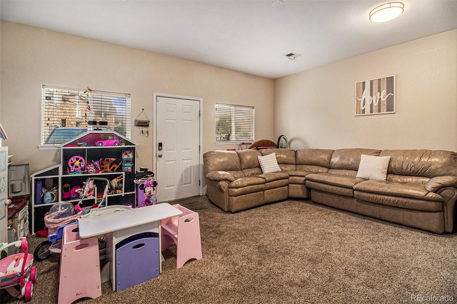 10818 Cimarron Street, Unit 1202 Firestone, CO 80504 - Photo 12 of 13 a living room with furniture and a flat screen tv