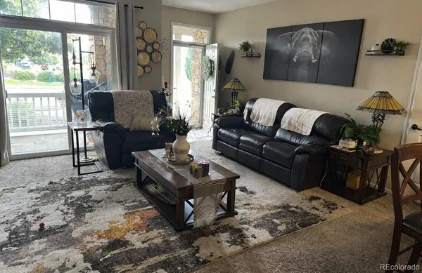 a living room with furniture wooden floor and a large window