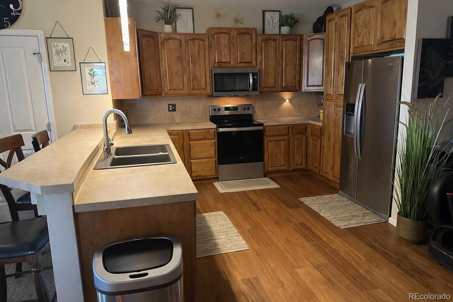10818 Cimarron Street, Unit 1202 Firestone, CO 80504 - Photo 4 of 13 a kitchen with a sink a stove and a refrigerator