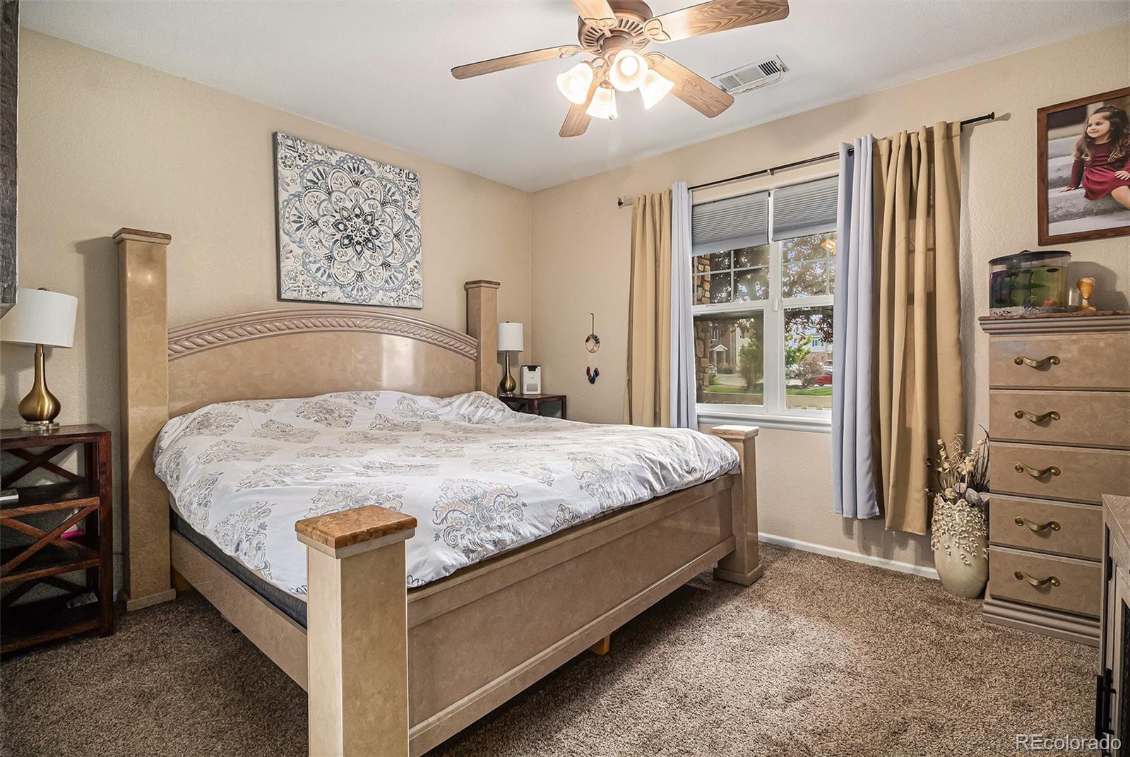 10818 Cimarron Street, Unit 1202 Firestone, CO 80504 - Photo 5 of 13 a bedroom with a bed and a dresser