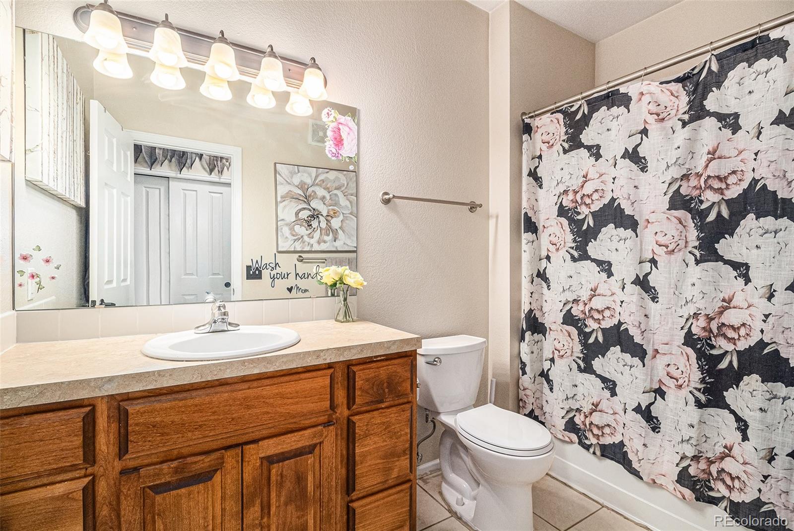 10818 Cimarron Street, Unit 1202 Firestone, CO 80504 - Photo 9 of 13 a bathroom with a sink a toilet and shower curtain