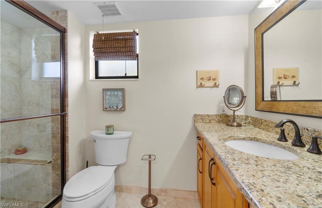 5890 Via Lugano, Unit 101 Naples, FL 34108 - Photo 18 of 22 a bathroom with a granite countertop sink toilet and a mirror