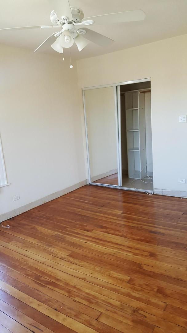 4764 North Virginia Avenue, Unit 206 Chicago, IL 60625 - Photo 11 of 16 a view of an empty room with wooden floor and a ceiling fan