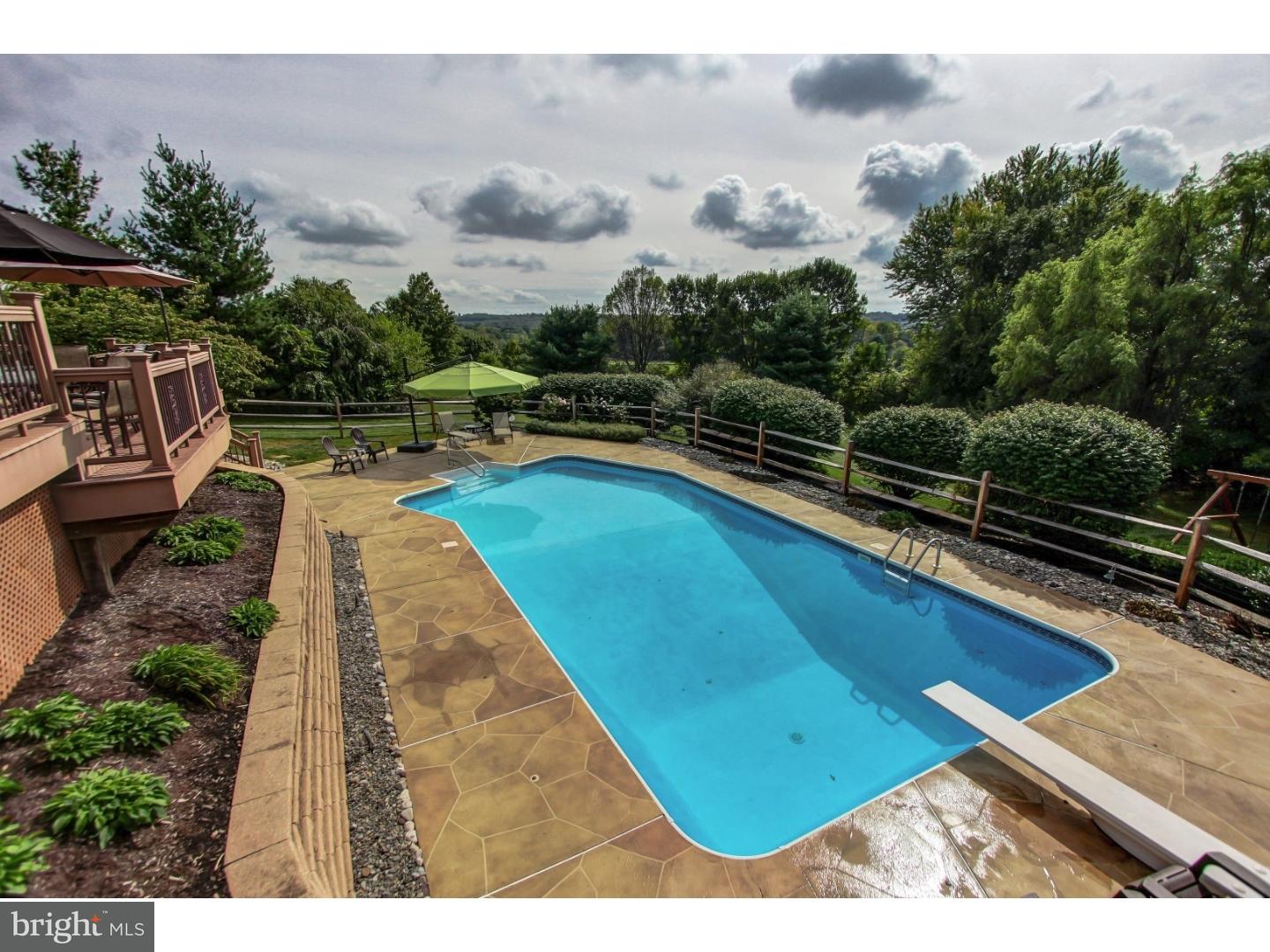5237 Windtree Drive Doylestown, PA 18902 - Photo 24 of 25 a view of a swimming pool with lawn chairs under an umbrella