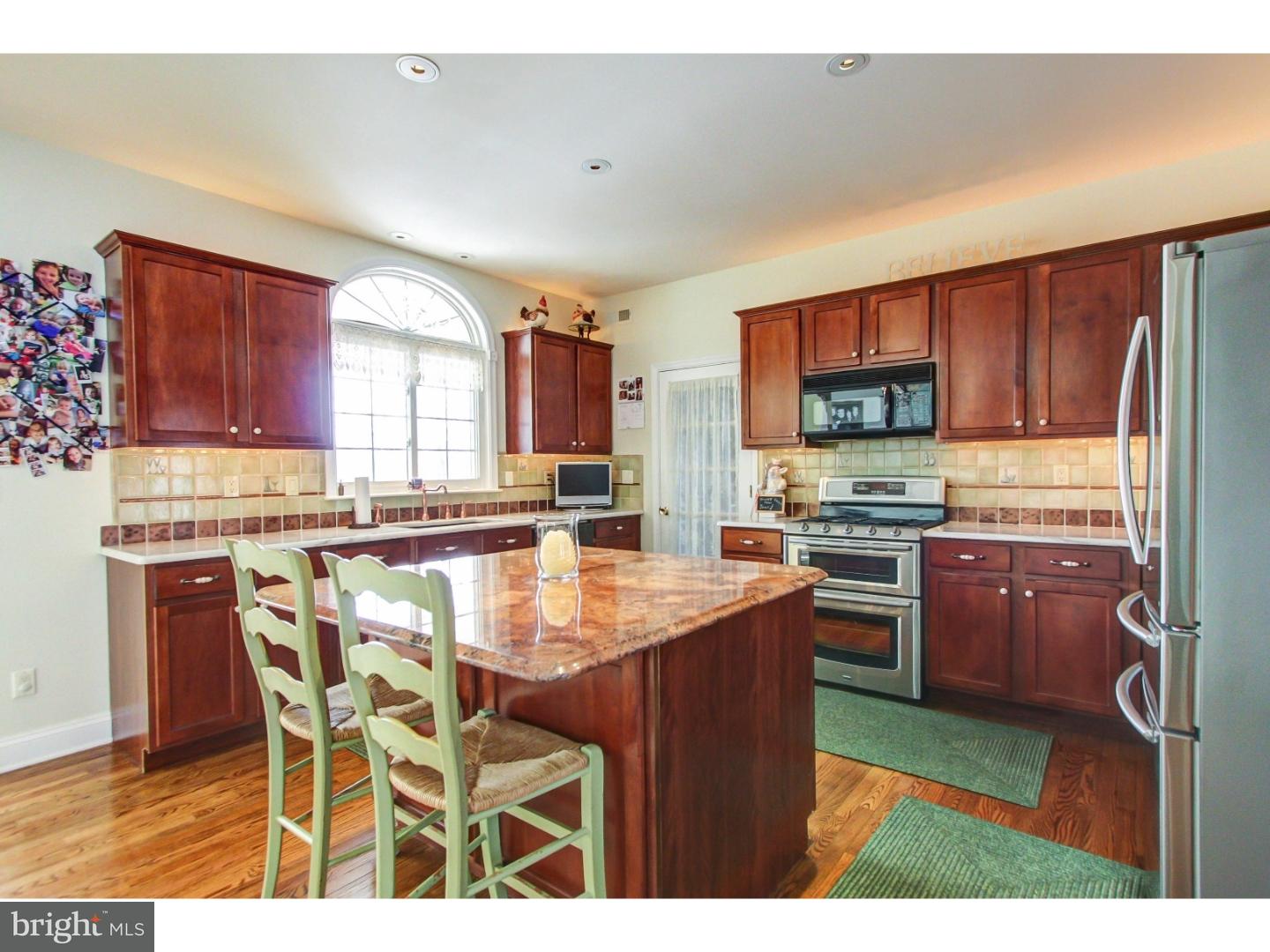 5237 Windtree Drive Doylestown, PA 18902 - Photo 9 of 25 a kitchen with stainless steel appliances kitchen island granite countertop a stove a sink a microwave a dining table and chairs