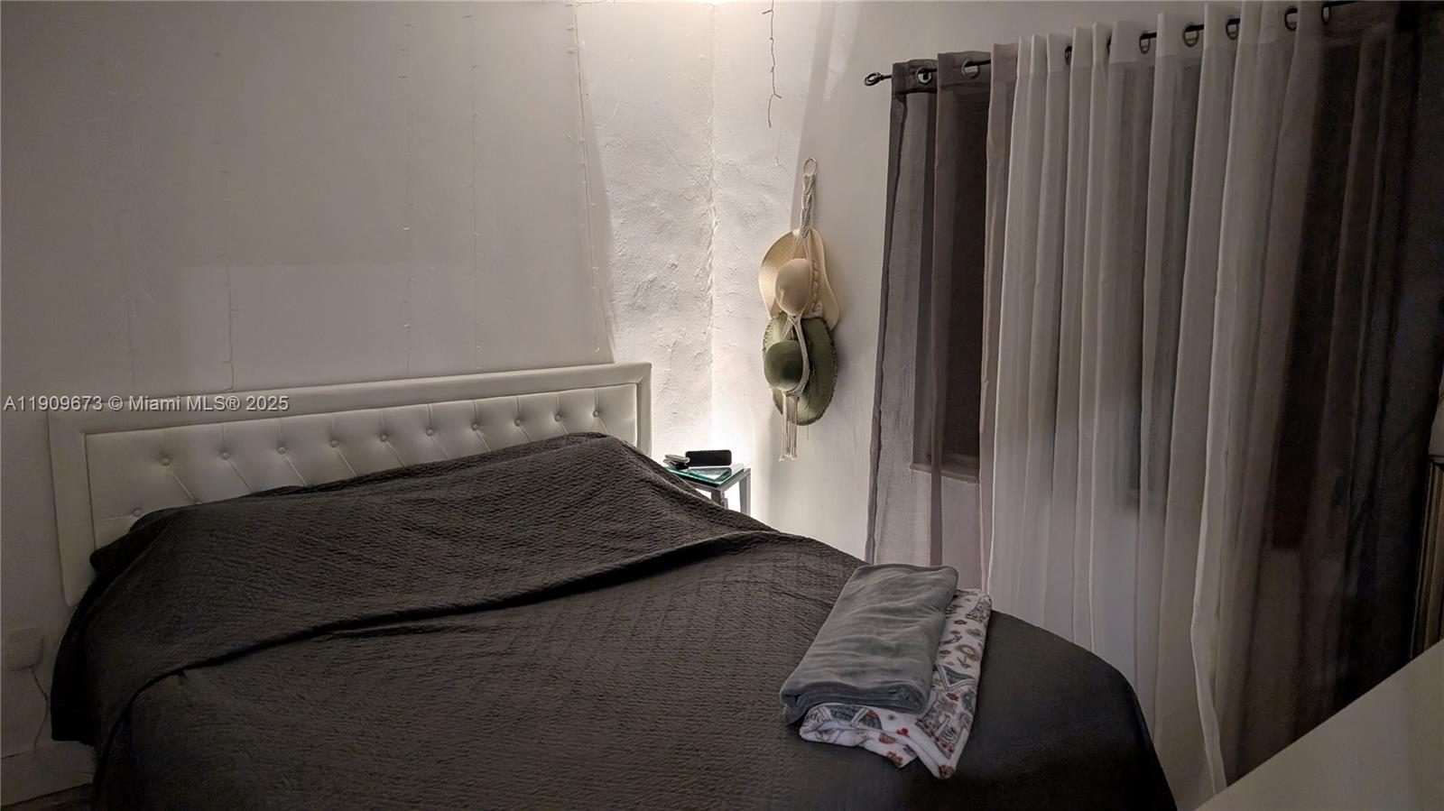 917-919 Northeast 10th Street Hallandale Beach, FL 33009 - Photo 3 of 10 a bedroom with a bed and a window