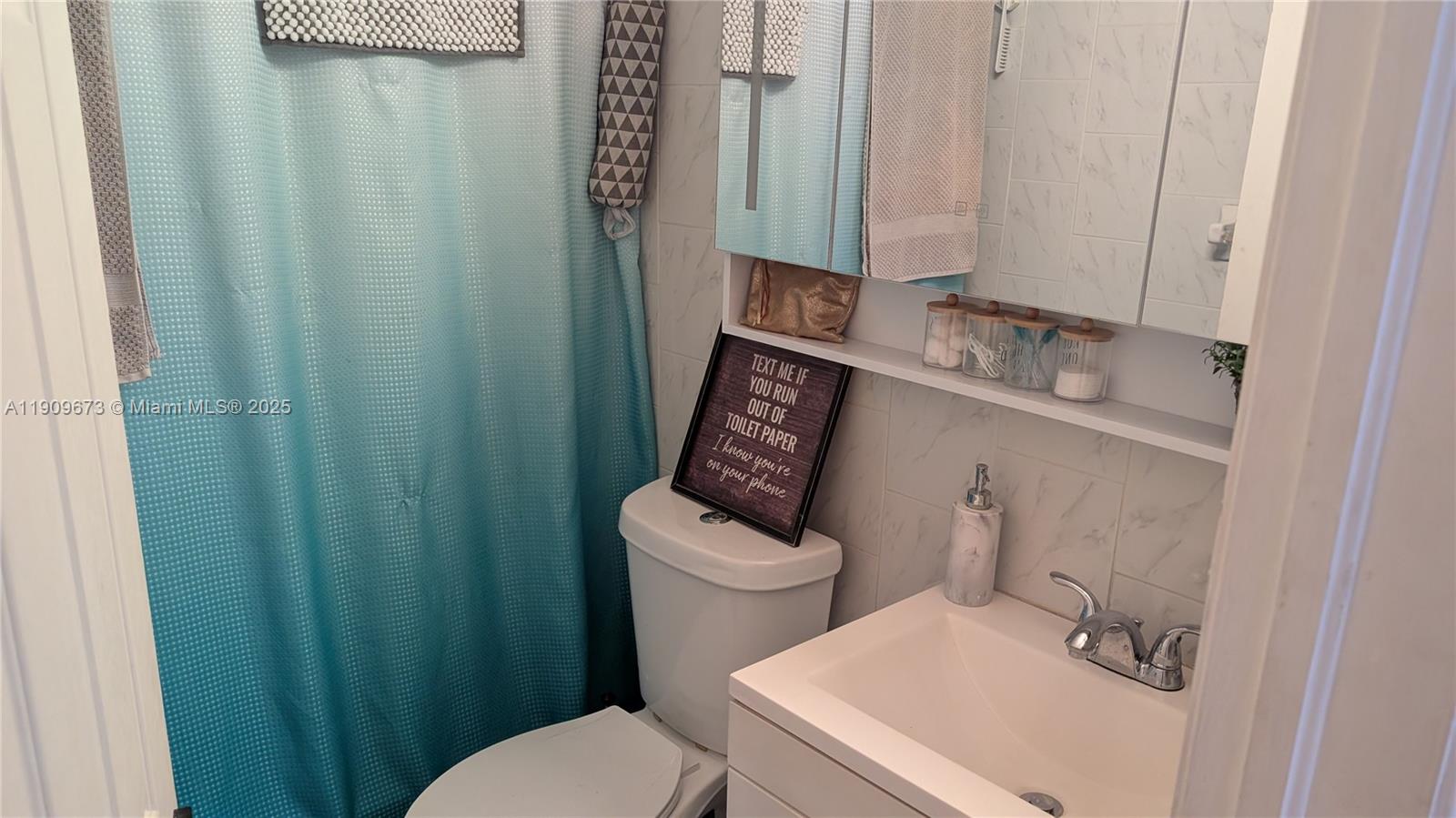 917-919 Northeast 10th Street Hallandale Beach, FL 33009 - Photo 7 of 10 a white toilet sitting next to a bathroom sink