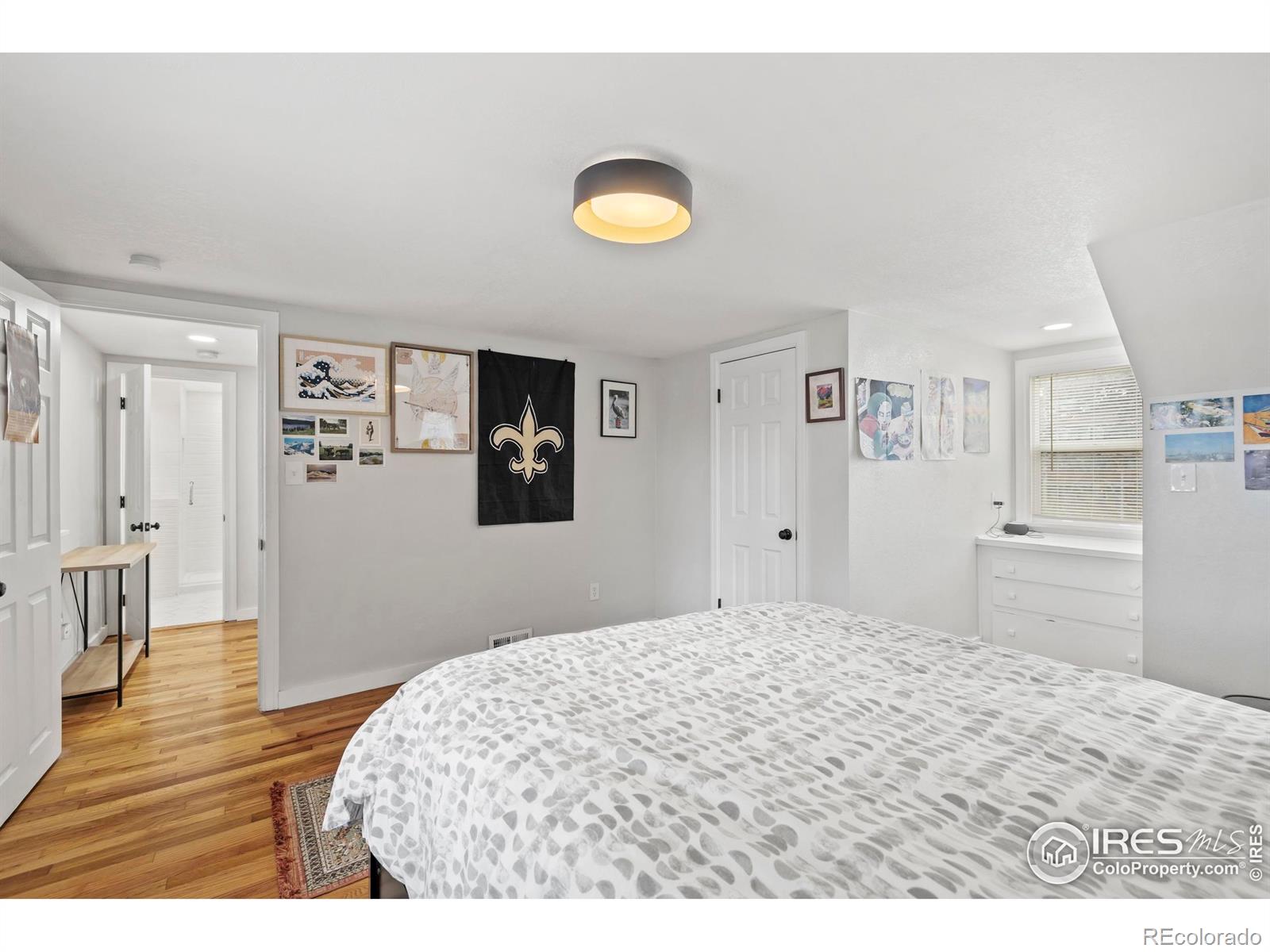 814 West Laurel Street Fort Collins, CO 80521 - Photo 18 of 35 a bedroom with a bed and a table with wooden floor
