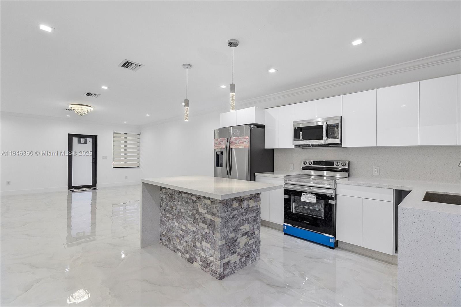 501 East 59th Street Hialeah, FL 33013 - Photo 12 of 29 a large kitchen with stainless steel appliances granite countertop a stove top oven a sink dishwasher and a refrigerator with wooden floor