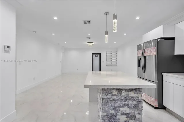 a view of a kitchen with a sink and a refrigerator