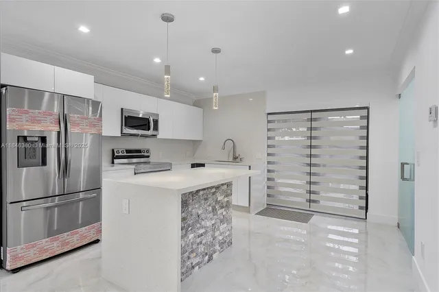 a kitchen with stainless steel appliances a refrigerator sink and microwave