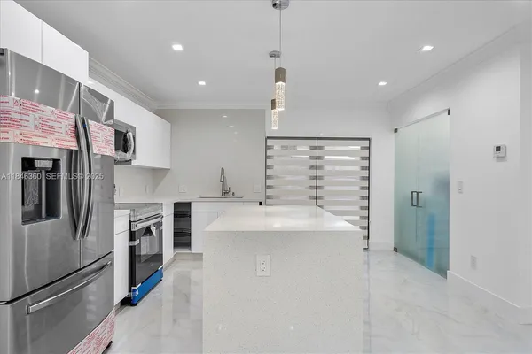 a kitchen with kitchen island a sink stainless steel appliances and cabinets