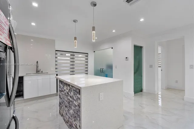a kitchen with kitchen island a sink stainless steel appliances and cabinets